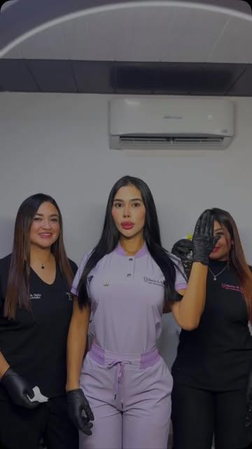 Tres integrantes del equipo con uniformes negro y lila
